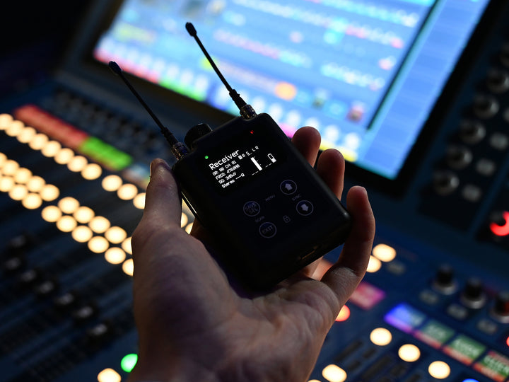 Wisycom MPR60 held in the hand, showing the OLED display and four-button control layout