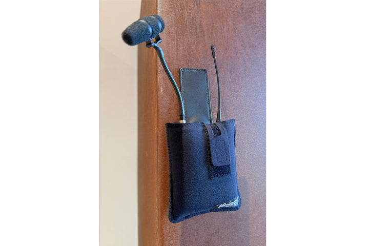 Viviana magnetic pouch held on a vertical wooden surface by its built-in magnets, rigged as a plant mic with transmitter and microphone